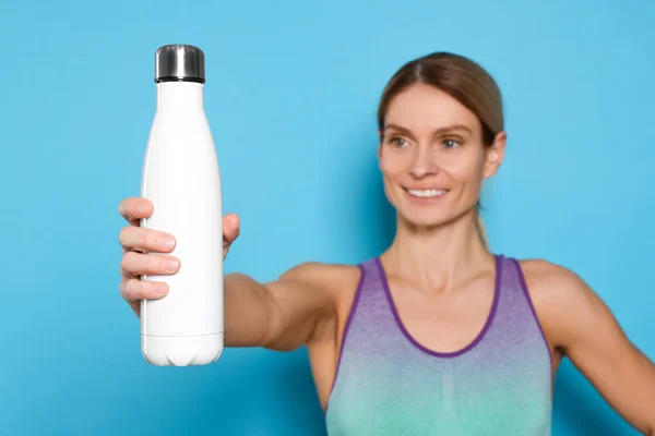 Sportlerin Mit Thermoflasche Auf Hellblauem Hintergrund — Stockfoto