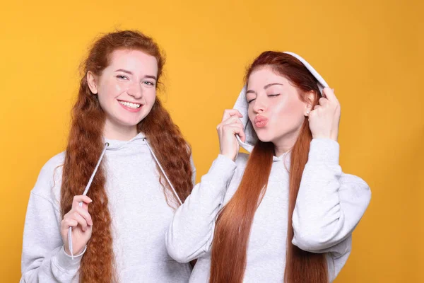 Turuncu Arka Planda Güzel Kızıl Saçlı Kız Kardeşlerin Portresi — Stok fotoğraf