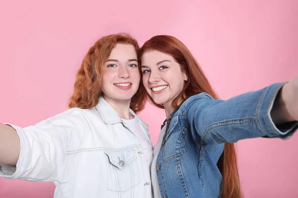 Güzel Kızıl Saçlı Kız Kardeşler Pembe Arka Planda Selfie Çekiyorlar — Stok fotoğraf