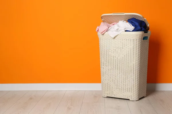 Open Laundry Basket Clothes Orange Wall Indoors Space Text — Stock Photo, Image