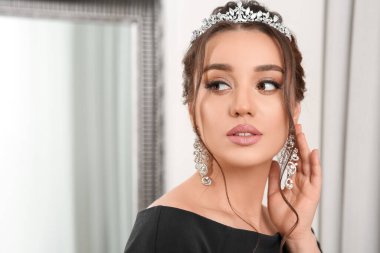 İçerde lüks bir taç takan genç ve güzel bir kadın.