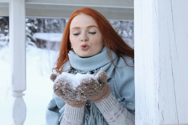 屋外の木製の展望台で手から雪を吹いて女性 冬休み — ストック写真