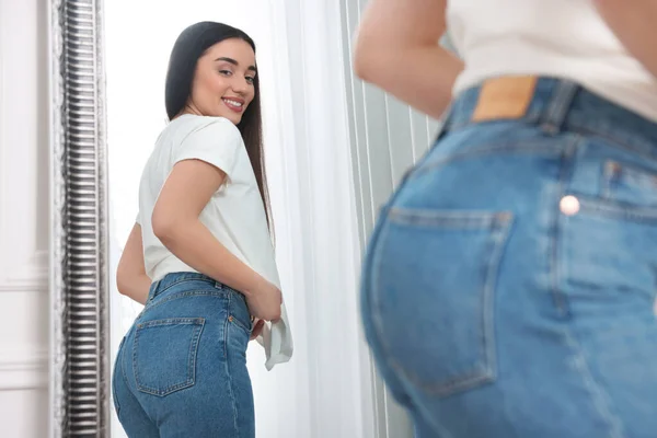 Wanita Muda Dengan Celana Jeans Gaya Dekat Cermin Dalam Ruangan — Stok Foto