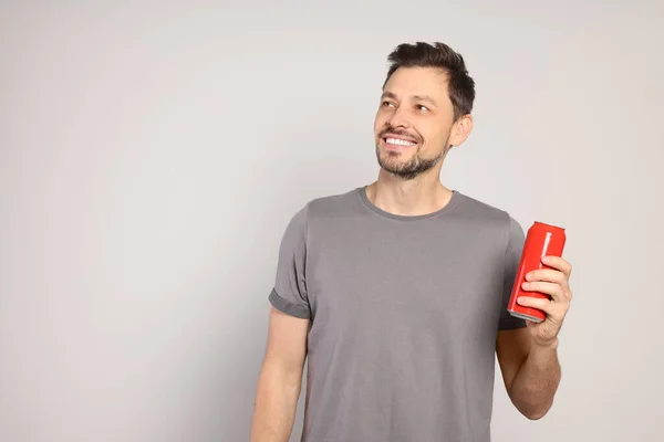Ευτυχισμένος Άνθρωπος Κρατώντας Κόκκινο Τενεκεδάκι Ποτό Ανοιχτό Γκρι Φόντο Χώρος — Φωτογραφία Αρχείου