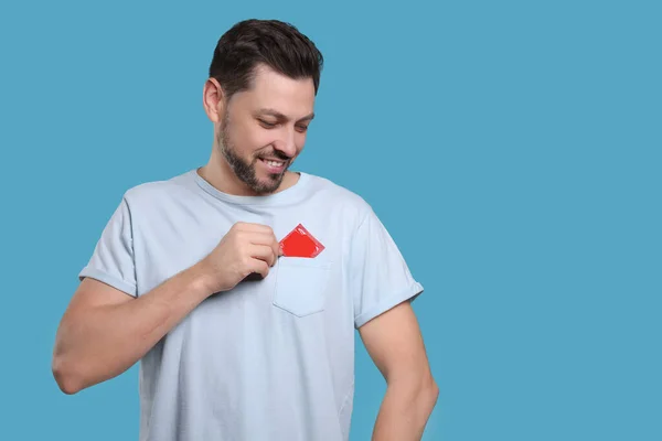 Smiling Man Putting Condom His Pocket Light Blue Background Space — Stock Photo, Image