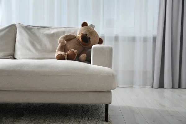 在房间的沙发上可爱孤独的泰迪熊 案文的篇幅 — 图库照片