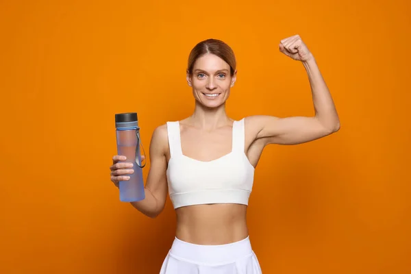 Sportlerin Mit Flasche Wasser Auf Orangefarbenem Hintergrund — Stockfoto