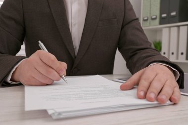 Ahşap masada belge imzalayan adam, yakın plan