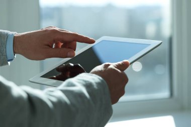 Kapalı alanda yeni tablet kullanan adamın yakın görüntüsü