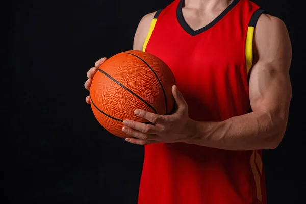 黒の背景にバスケットボールボールを持つアスレチックマン クローズアップ — ストック写真