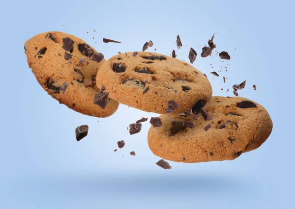 おいしいチョコレートチップクッキーは薄い青の背景に落ちます — ストック写真