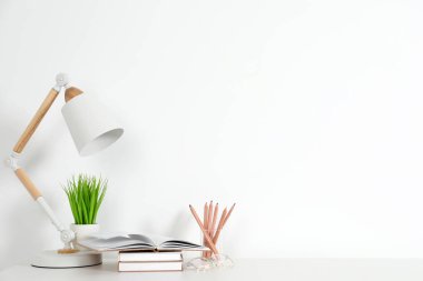 Duvarın yanında beyaz masası olan rahat bir iş yeri. Metin için boşluk