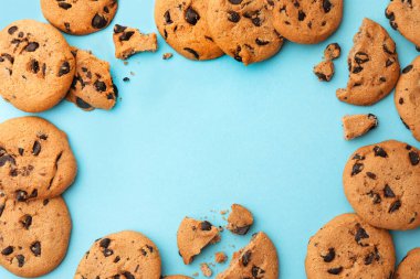 Açık mavi arka planda bir sürü çikolatalı kurabiyeden yapılmış bir çerçeve. Metin için boşluk