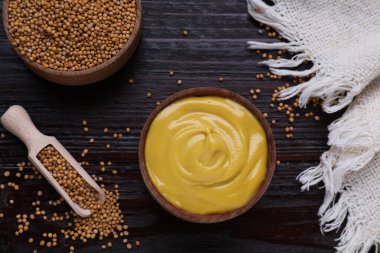 Lezzetli hardal ve tohumlar koyu ahşap masada, düz yerde.