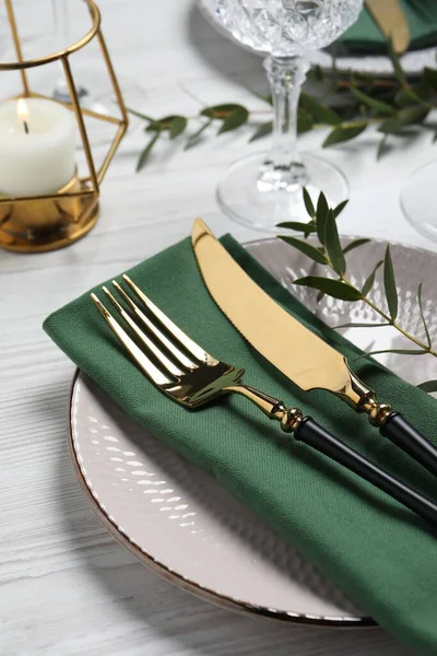 用餐具和桉树叶装饰在白色木制桌子上的时尚布景 — 图库照片