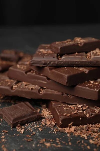 Куски Стружки Вкусного Шоколада Тёмном Столе Крупным Планом — стоковое фото