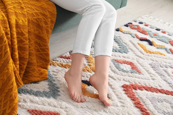Woman on carpet with pattern at home, closeup