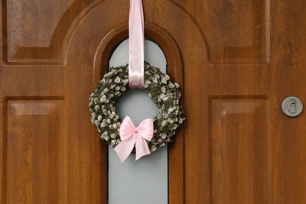stock image Wreath made of beautiful willow branches and pink bow on wooden door