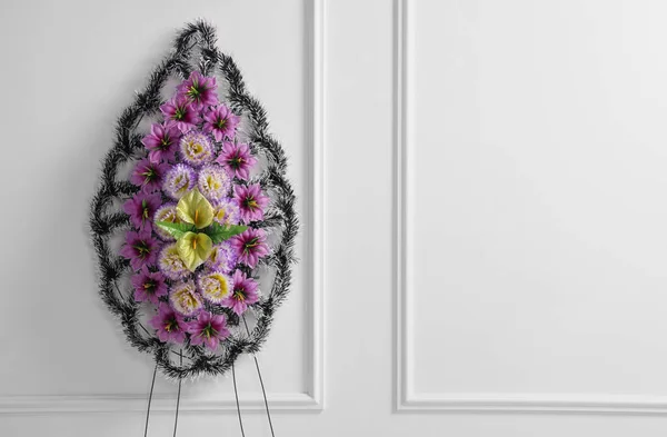 Wieniec Pogrzebowy Plastikowych Kwiatów Przy Białej Ścianie Miejsce Tekst — Zdjęcie stockowe