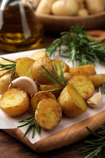 羊皮纸上有迷迭香和大蒜的美味烤土豆 — 图库照片
