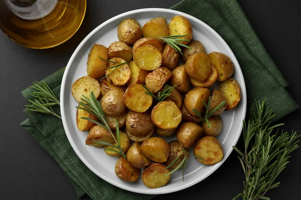 Batatas Assadas Deliciosas Com Alecrim Óleo Mesa Preta Vista Superior — Fotografia de Stock