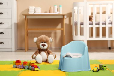 Açık mavi bebek lazımlığı ve oyuncaklar odada. Tuvalet eğitimi