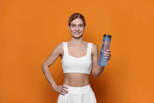 Sportvrouw Met Flesje Water Oranje Achtergrond — Stockfoto
