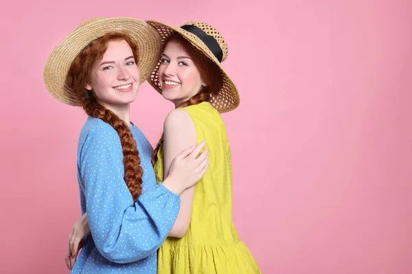 Pembe Arka Planda Hasır Şapkalı Güzel Kızıl Saçlı Kız Kardeşlerin — Stok fotoğraf