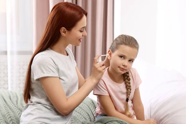 Mother Spraying Medication Daughter Ear Bedroom — Stock Photo, Image