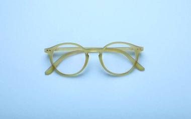 Açık mavi arkaplanda düzeltici lensli gözlük, üst görünüm