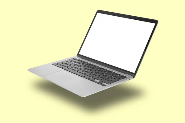 노란색 배경으로 날으는 현대식 노트북 — 스톡 사진
