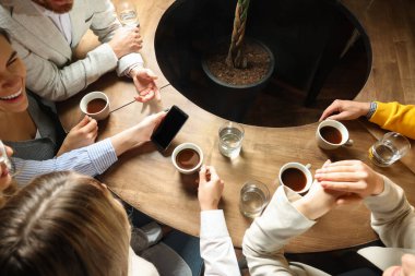 Kahveli arkadaşlar birlikte kafede vakit geçiriyorlar.