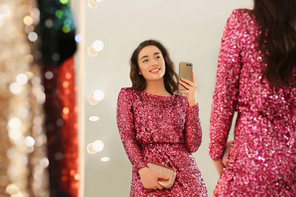 Schöne Junge Frau Probiert Ein Stylisches Pinkfarbenes Paillettenkleid Und Macht — Stockfoto