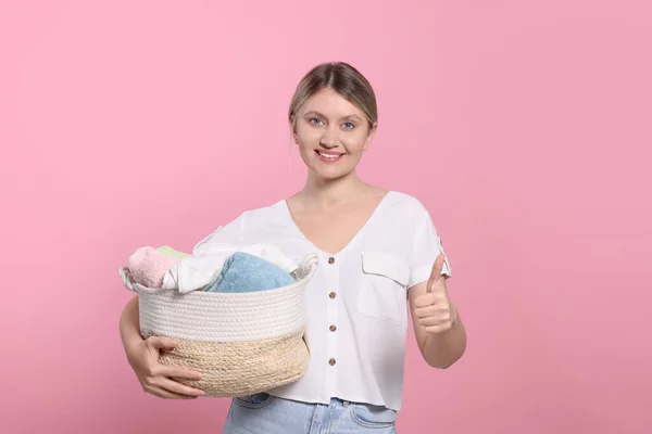 Šťastná Žena Košíkem Plným Prádla Ukazující Palec Nahoru Růžovém Pozadí — Stock fotografie