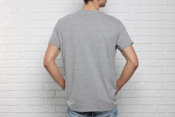 Man Wearing Gray Shirt White Brick Wall Back View Mockup — Stock Photo, Image