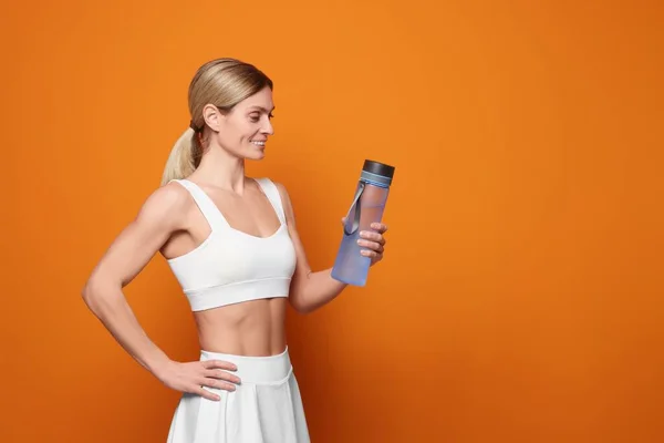 Sportlerin Mit Wasserflasche Auf Orangefarbenem Hintergrund Platz Für Text — Stockfoto