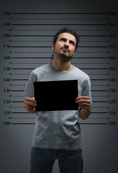 Criminele Politiefoto Gearresteerde Man Met Blanco Kaart Tegen Lengteschema — Stockfoto