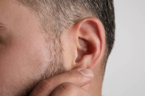 Man Touching His Ear Light Grey Background Closeup — Stock Photo, Image