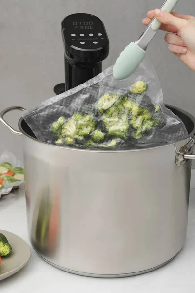 Woman Putting Vacuum Packed Broccoli Pot Sous Vide Cooker Closeup — 스톡 사진