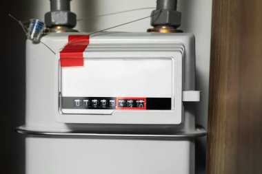 Beyaz duvarın yanındaki elektrik sayacı, yakın plan. Gaz Ölçüm Cihazı