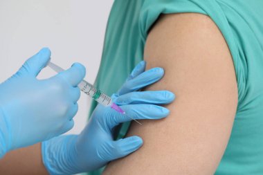 Doktor klinikteki hastaya hepatit aşısı veriyor.