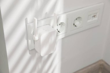 Beyaz duvarda kablosuz kablosuz kablosuz ağ yineleyici var.