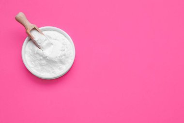 Pembe arka planda bir kase tatlı toz früktoz, üst manzara. Metin için boşluk