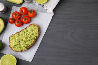 Guacamole soslu lezzetli sandviç, domates ve limonlu gri ahşap masa, düz yatak. Metin için boşluk