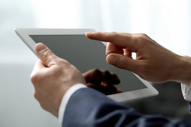 Kapalı alanda yeni tablet kullanan adamın yakın görüntüsü