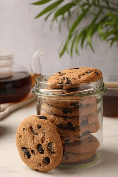 Glasgefäß Mit Leckeren Schokoladenkeksen Und Tee Auf Weißem Marmortisch — Stockfoto
