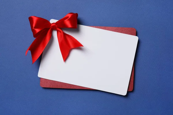 Blanko Geschenkkarte Mit Roter Schleife Auf Blauem Hintergrund Draufsicht Raum — Stockfoto