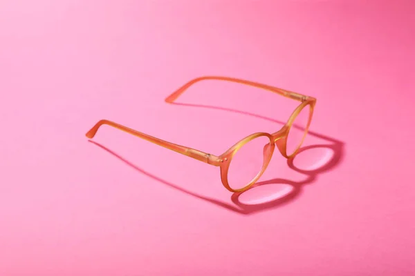 明るいピンクの背景に是正レンズを持つ眼鏡 — ストック写真
