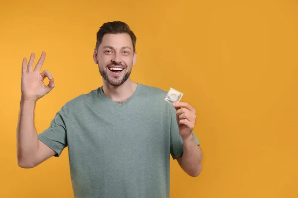 Happy Man Condom Showing Gesture Orange Background Space Text — Stock Photo, Image