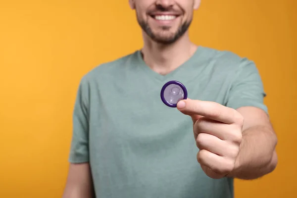 오렌지 배경에 콘돔을 클로즈업 — 스톡 사진